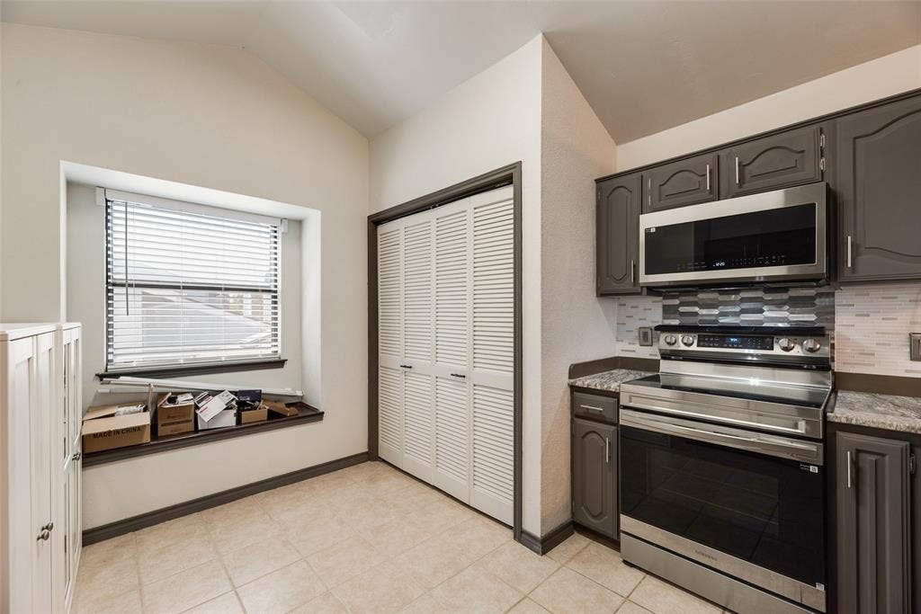 17490 Meandering Way, #202, Dallas, TX 75252 Stainless steel appliance suite, gray cabinetry, tile backsplash, and louvered closet doors