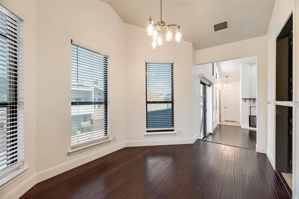 17490 Meandering Way, #202, Dallas, TX 75252 Vaulted ceiling, dark wood-finish flooring, two large windows with blinds, recessed lighting, and a modern brass chandelier