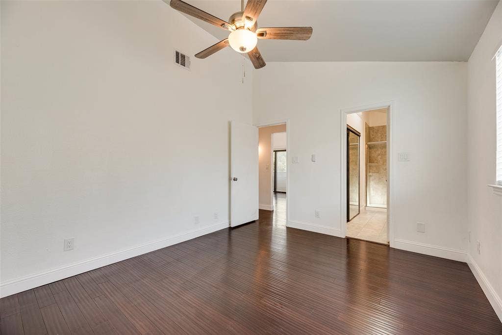 17490 Meandering Way, #202, Dallas, TX 75252 Vaulted ceiling with an attached ceiling fan, dark wood-finish flooring, white baseboards, and doorways to other interior spaces