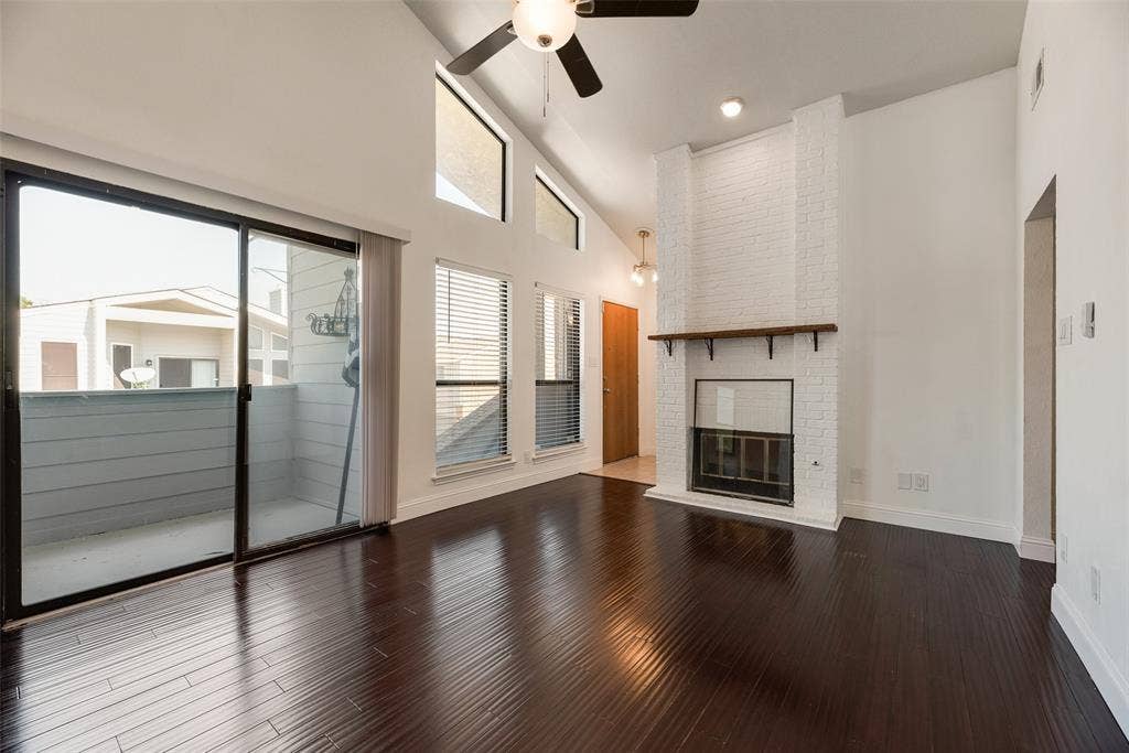 17490 Meandering Way, #202, Dallas, TX 75252 Vaulted ceilings, dark wood-finish flooring, and a white brick fireplace with a wood mantle