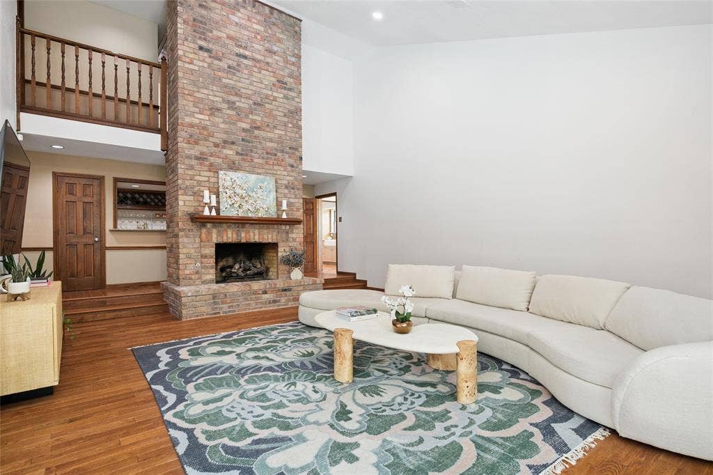 2001 Pebble Beach Court, Richardson, TX 75082 Make memories here with a stunning floor to ceiling brick fireplace that centers the living area. Rich hardwood floors everywhere with access to wet bar.