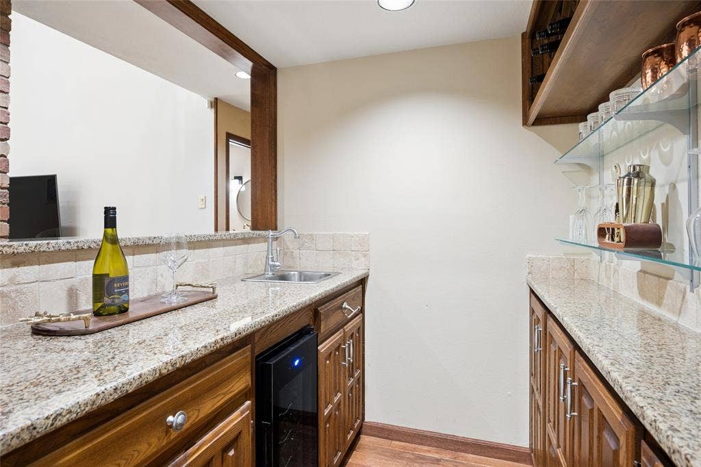 2001 Pebble Beach Court, Richardson, TX 75082 Entertaining made easy with a wet bar complete with granite counters & wine-beverage fridge, positioned just off the living area.