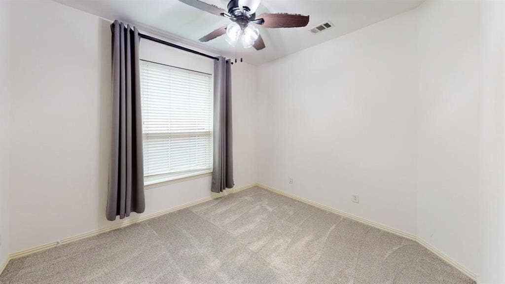 Neutral-toned wall-to-wall carpeting, window with blinds, and ceiling fan with integrated lighting