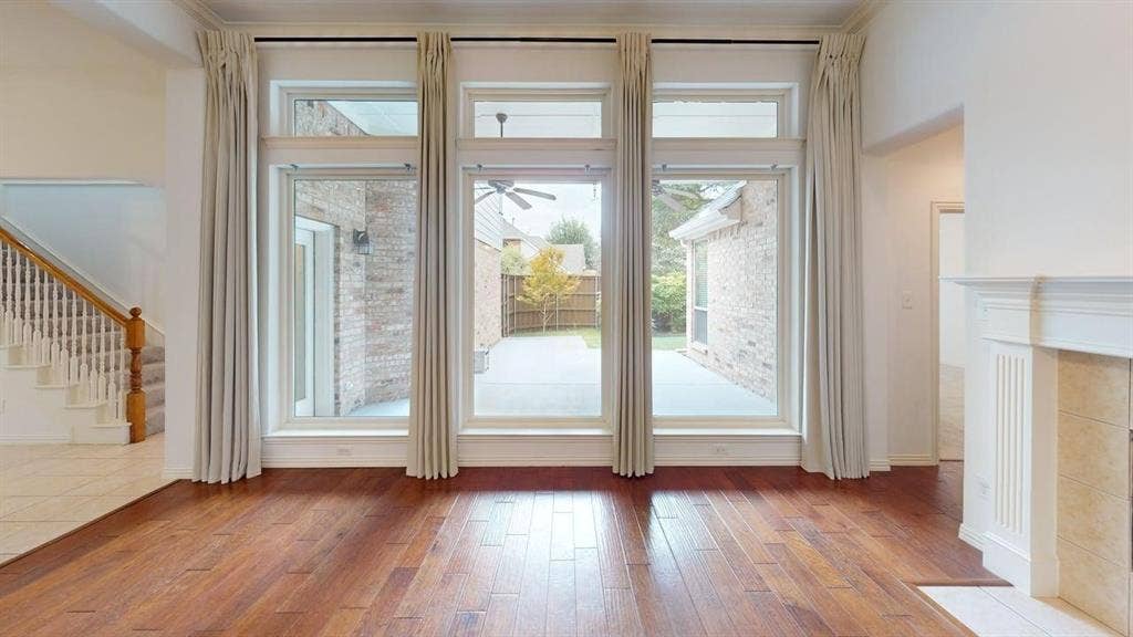 Hardwood flooring, multi-pane windows, a built-in fireplace with mantle, and a staircase with wood newel posts