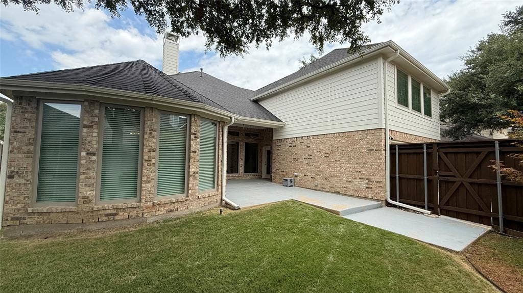 Brick and siding exterior with a dark shingle roof