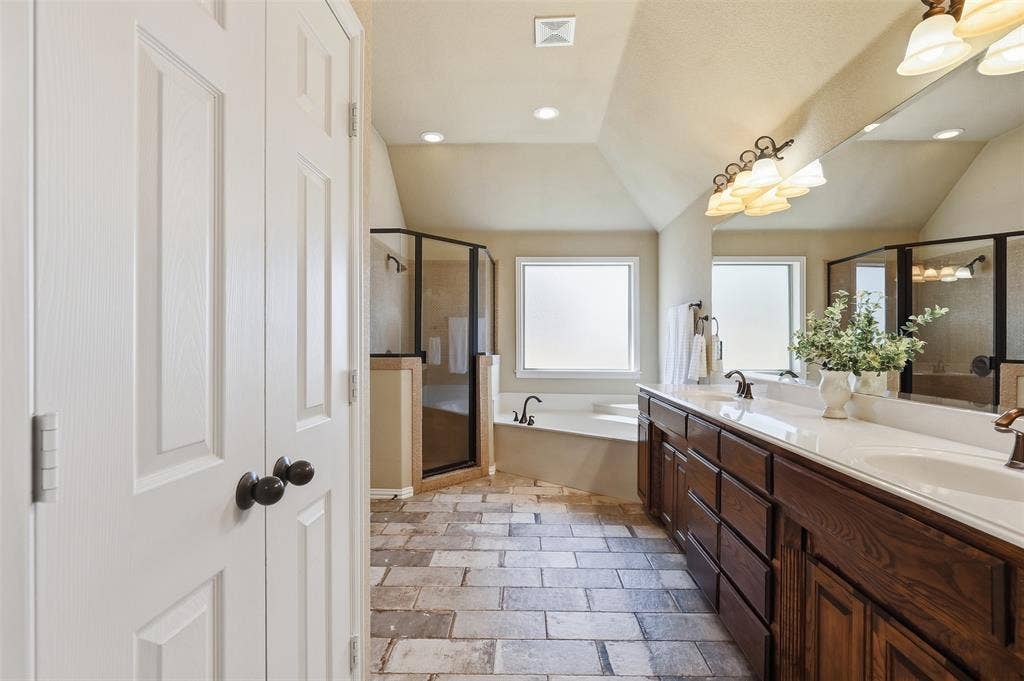 Dual vanity with undermount sinks, brown wood-finish cabinetry, and a large mirror