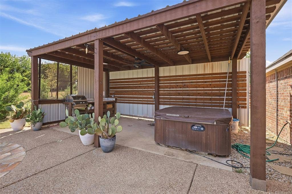 Covered patio structure with a corrugated metal roof and exposed wood beams