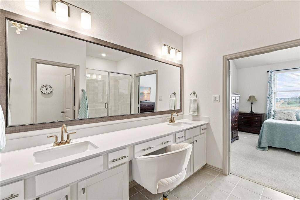 612 4th Street, Argyle, TX 76226 Dual vanity with white cabinetry, and a large framed mirror