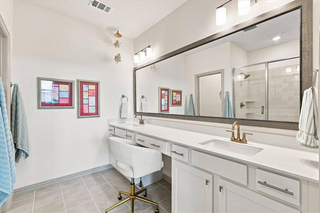 612 4th Street, Argyle, TX 76226 Modern white countertops with dual vanities and a seated make-up station.