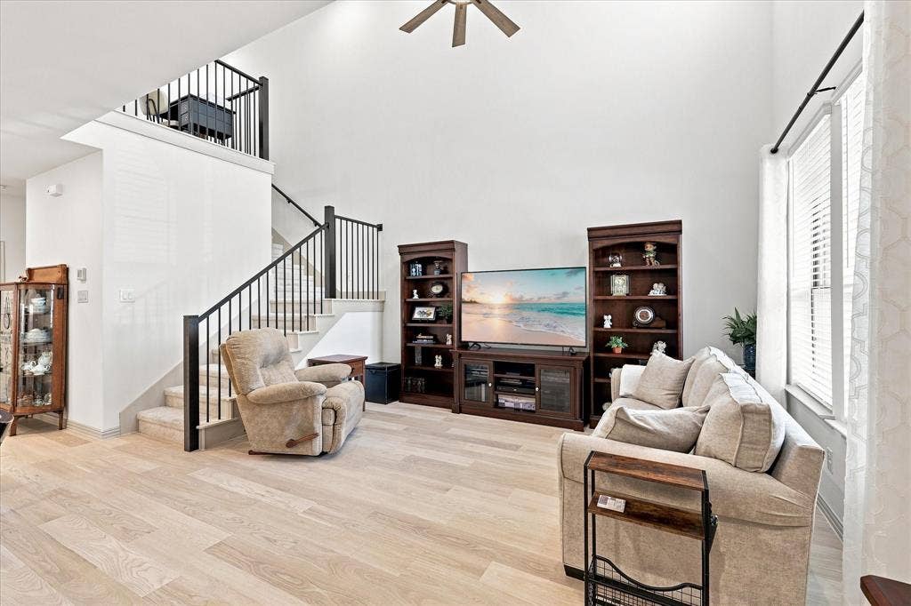 612 4th Street, Argyle, TX 76226 Ceiling fan and upper shades added to these soaring ceilings enhance the living room and allow neutral natural lighting.