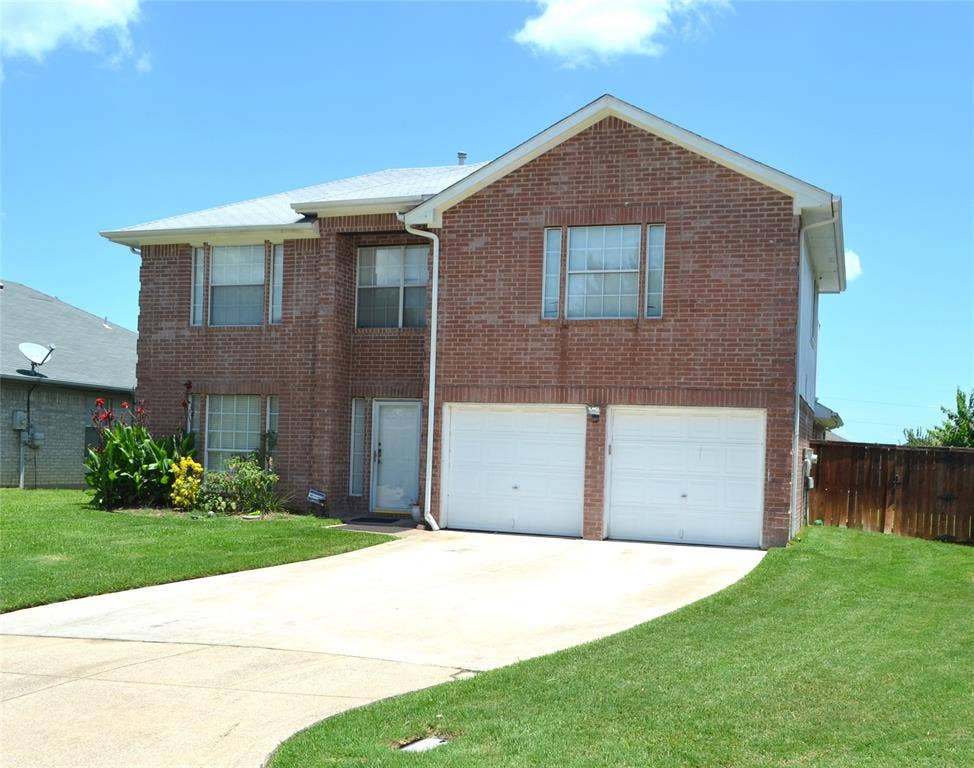 3994 Sword Dancer Way, Grand Prairie, TX 75052 Brick exterior with a two-car garage, white garage doors, and a concrete driveway