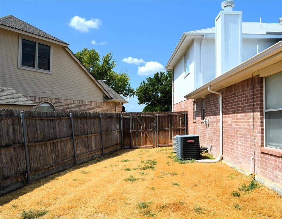 3994 Sword Dancer Way, Grand Prairie, TX 75052 Brick exterior with white trim, wood privacy fence, and an outdoor HVAC unit