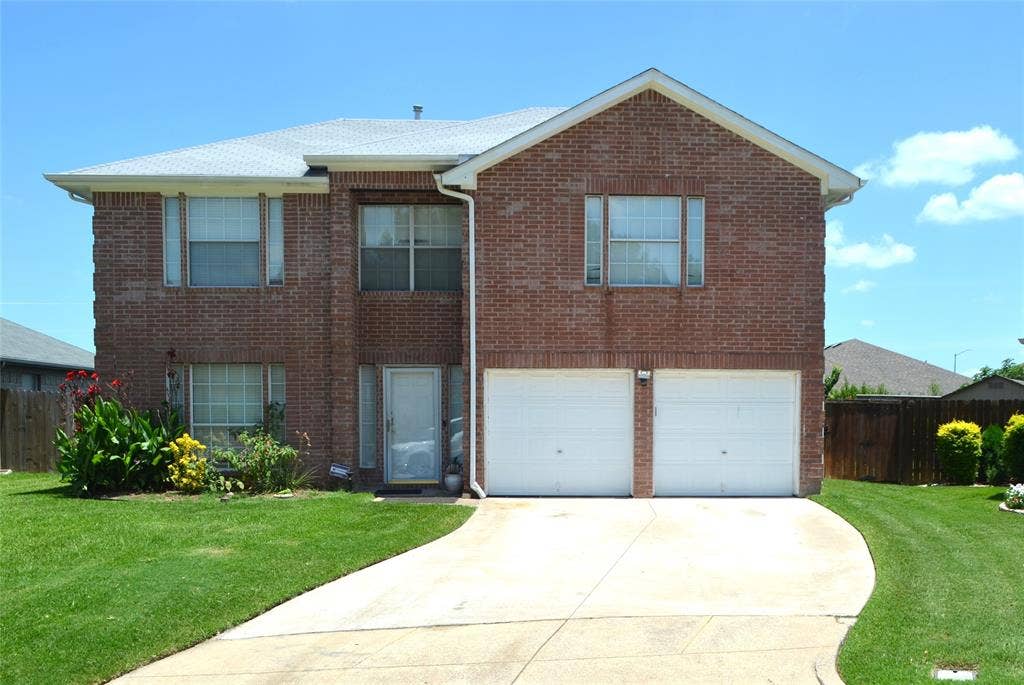 3994 Sword Dancer Way, Grand Prairie, TX 75052 Brick exterior residence featuring a two-car garage, concrete driveway, and front landscaping