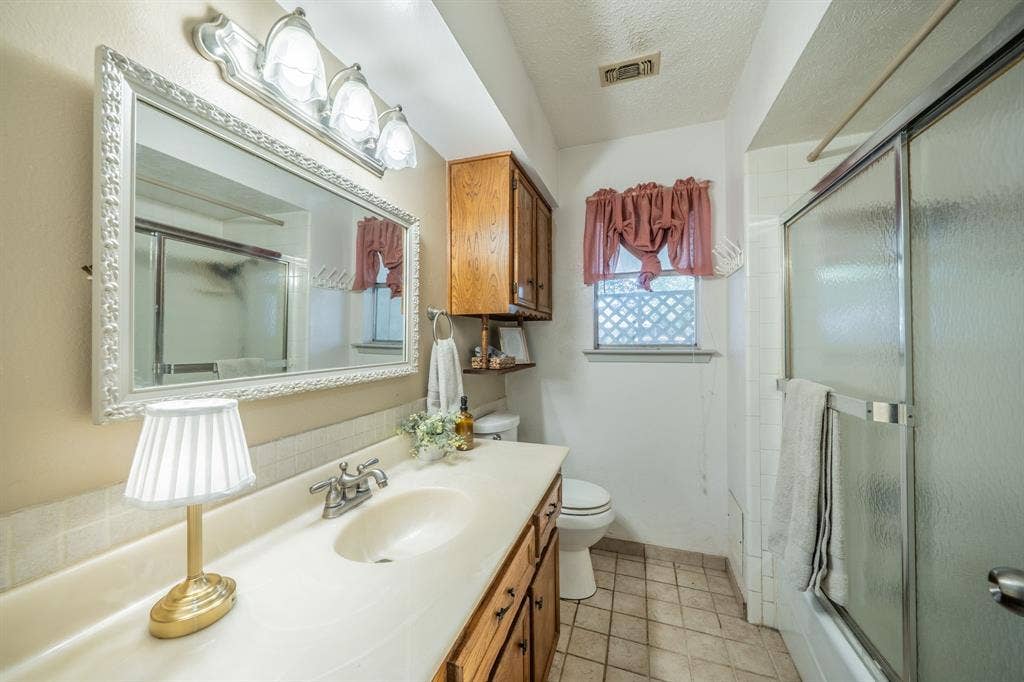 1517 Meadow Court, Midlothian, TX 76065 Vanity with integrated sink, wood-finish cabinetry, and framed mirror