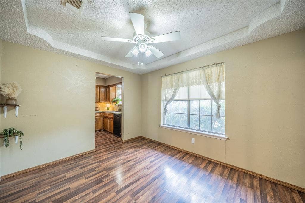 1517 Meadow Court, Midlothian, TX 76065 Tray ceiling with a ceiling fan, wood-finish flooring, and a large window
