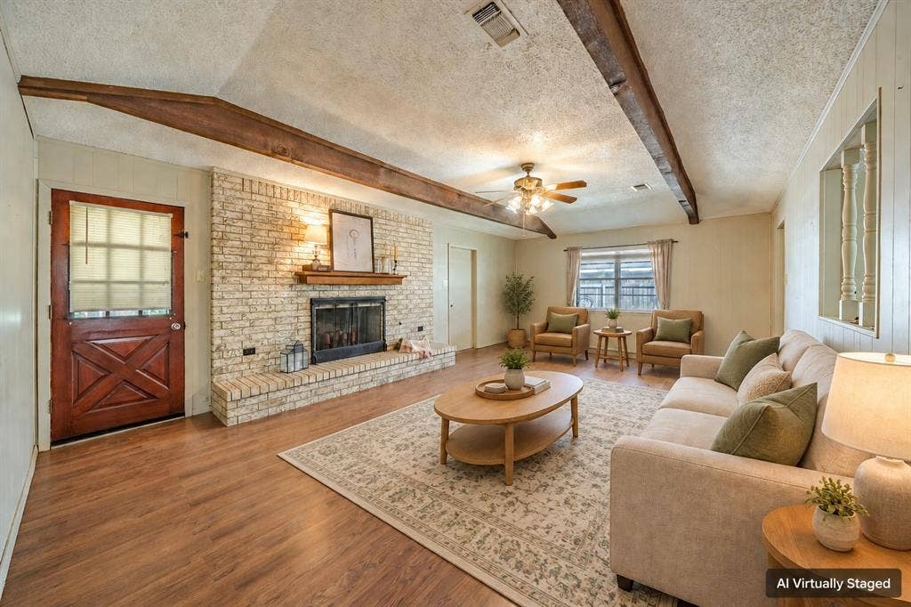 1517 Meadow Court, Midlothian, TX 76065 Living area featuring wood-finish flooring, exposed ceiling beams, a brick fireplace with a wood mantle, and a ceiling fan