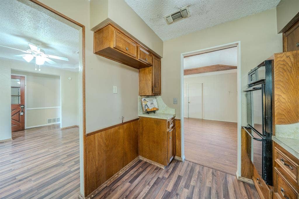 1517 Meadow Court, Midlothian, TX 76065 Wood-finish flooring throughout, wood paneling, and an integrated oven within wood cabinetry