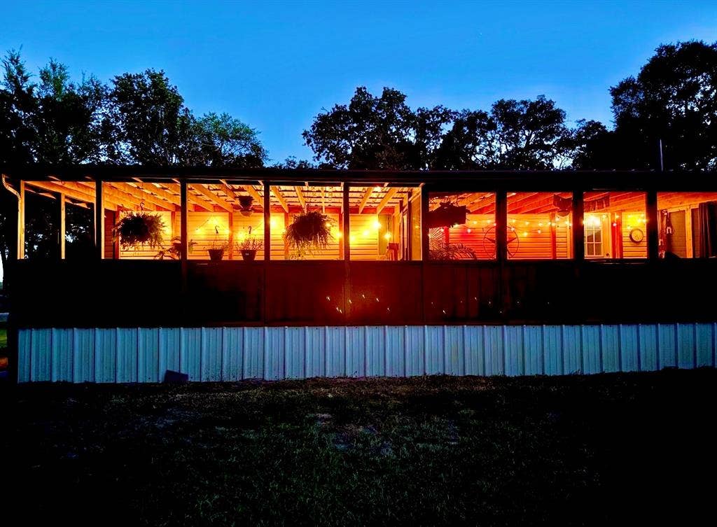 Well-lit back porch that looks out onto the acre long pond.  Home extends longer to the right as seen in the next photo