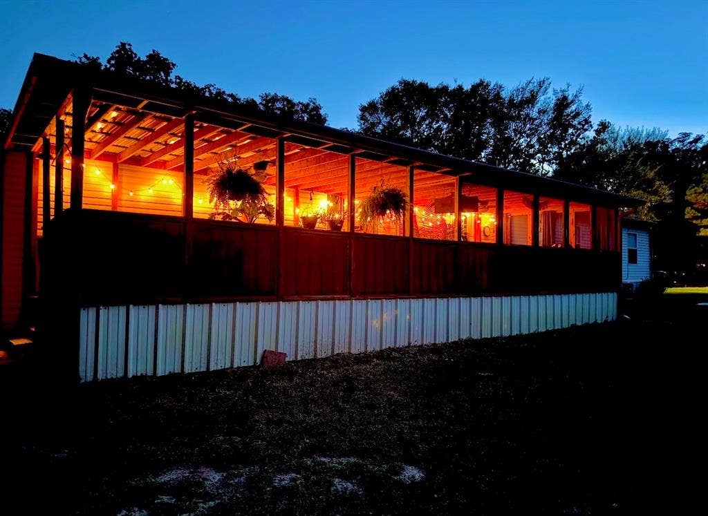 Expansive covered back porch of this double wide mobile home that lives like a custom single family home.