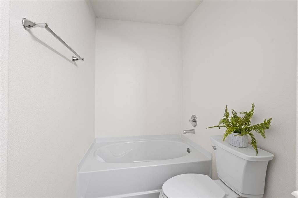 White soaking tub and toilet with chrome fixtures