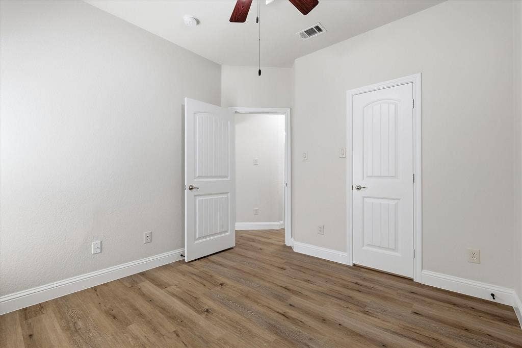 4516 Remuda Lane, Denton, TX 76226 Wood-finish flooring, white trim, white paneled doors, and a ceiling fan