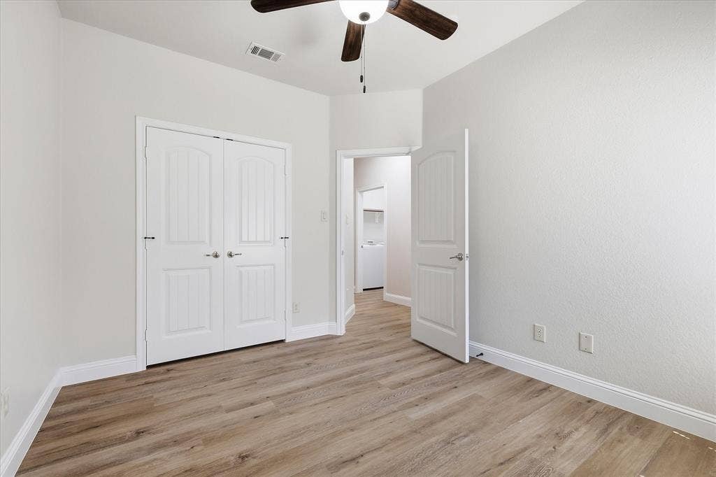 4516 Remuda Lane, Denton, TX 76226 Wood-finish flooring, white paneled doors, ceiling fan, and neutral wall tones