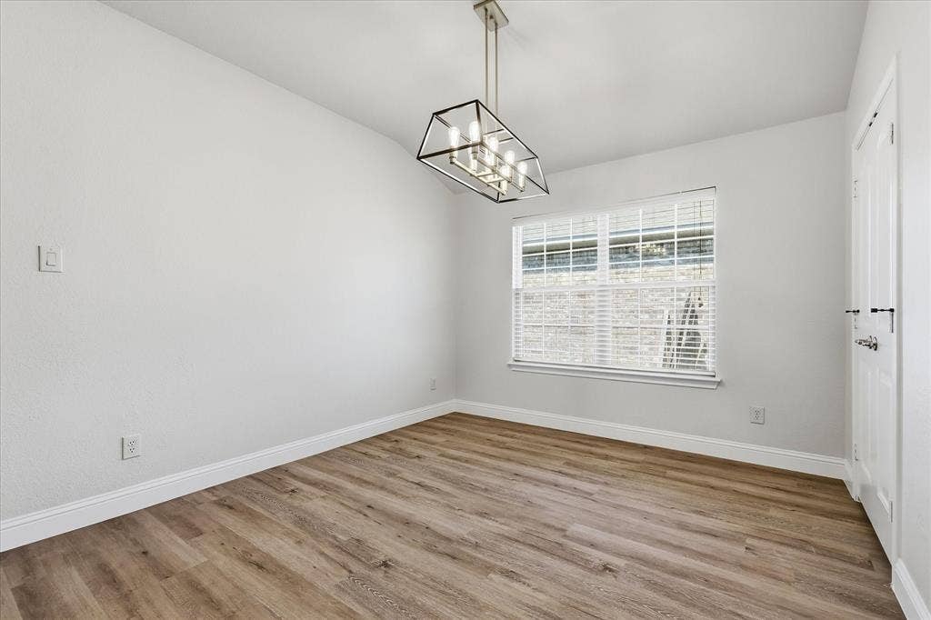4516 Remuda Lane, Denton, TX 76226 Wood-finish flooring with white baseboards, a suspended geometric chandelier, and a window with blinds