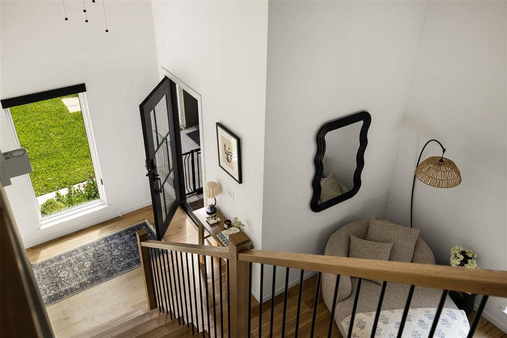 Hardwood flooring, black framed glass door, wood and metal staircase, high ceilings, large window