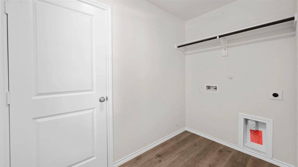 5614 Gannet Place, Crandall, TX 75114 Laundry area with wood-finish flooring, white walls, and a hanging rod