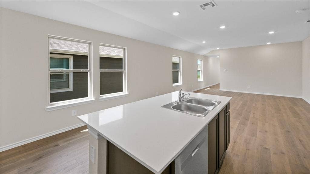 5622 Gannet Place, Crandall, TX 75114 Kitchen island featuring a double basin stainless steel sink with a single-handle pull-down faucet, a white countertop, and dark wood-finish cabinetry
