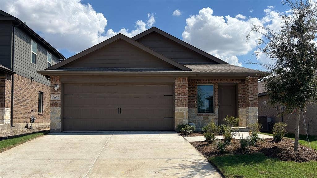 5622 Gannet Place, Crandall, TX 75114 Brick and stone exterior with a two-car garage, front landscaping, and a concrete driveway