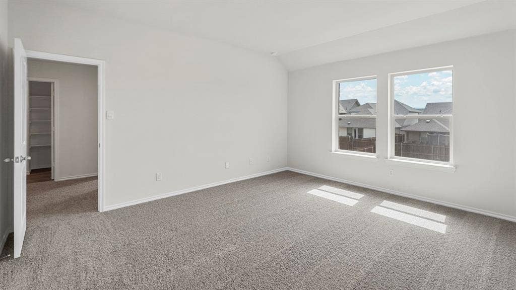 Spacious room featuring neutral carpeting and light gray walls