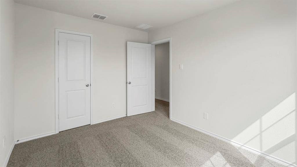 Carpeted interior space featuring white walls and white trim