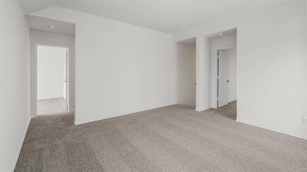 Spacious room featuring neutral carpeting and white wall finishes