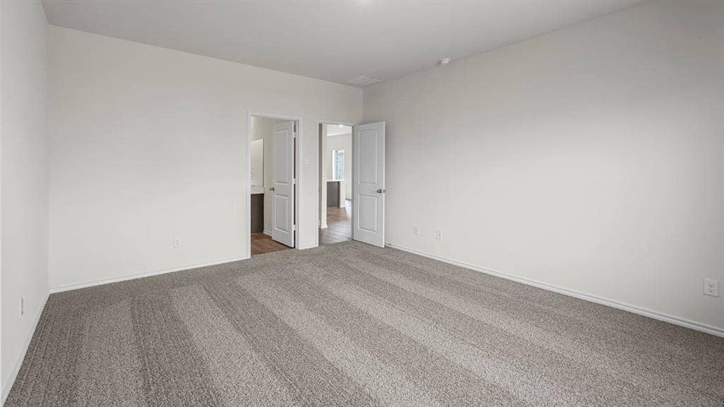 Spacious room featuring light gray carpeting and white painted walls