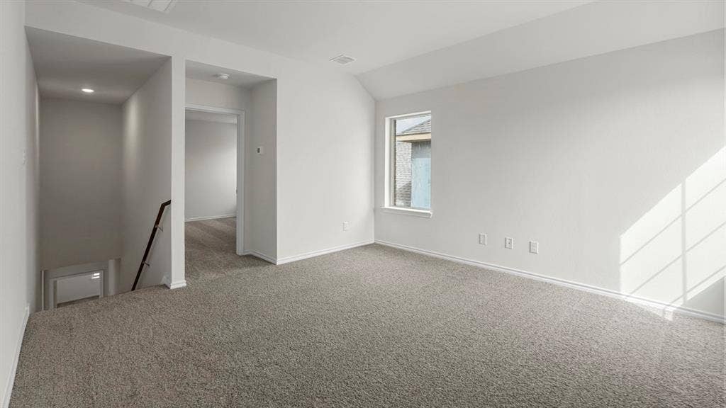 Carpeted open area with white walls and a single window