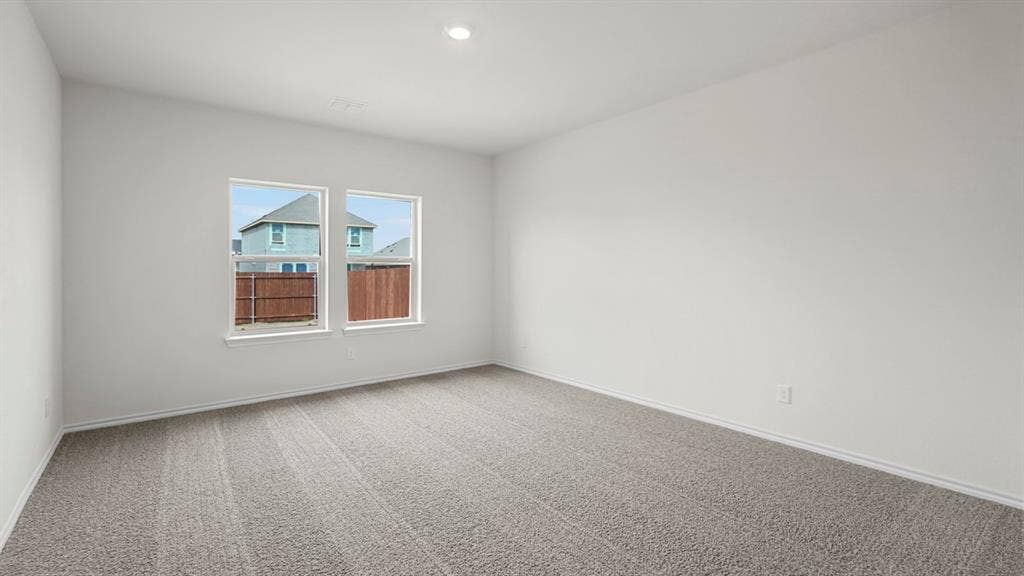Spacious interior room featuring light gray carpeting, crisp white walls, and two large windows