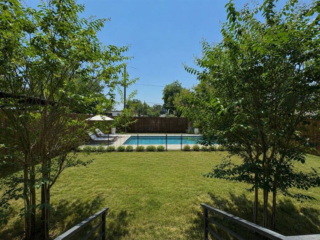 713 Wayne Street, Dallas, TX 75223 RENDERING Expansive lawn with a perimeter fence, mature trees, and a swimming pool
