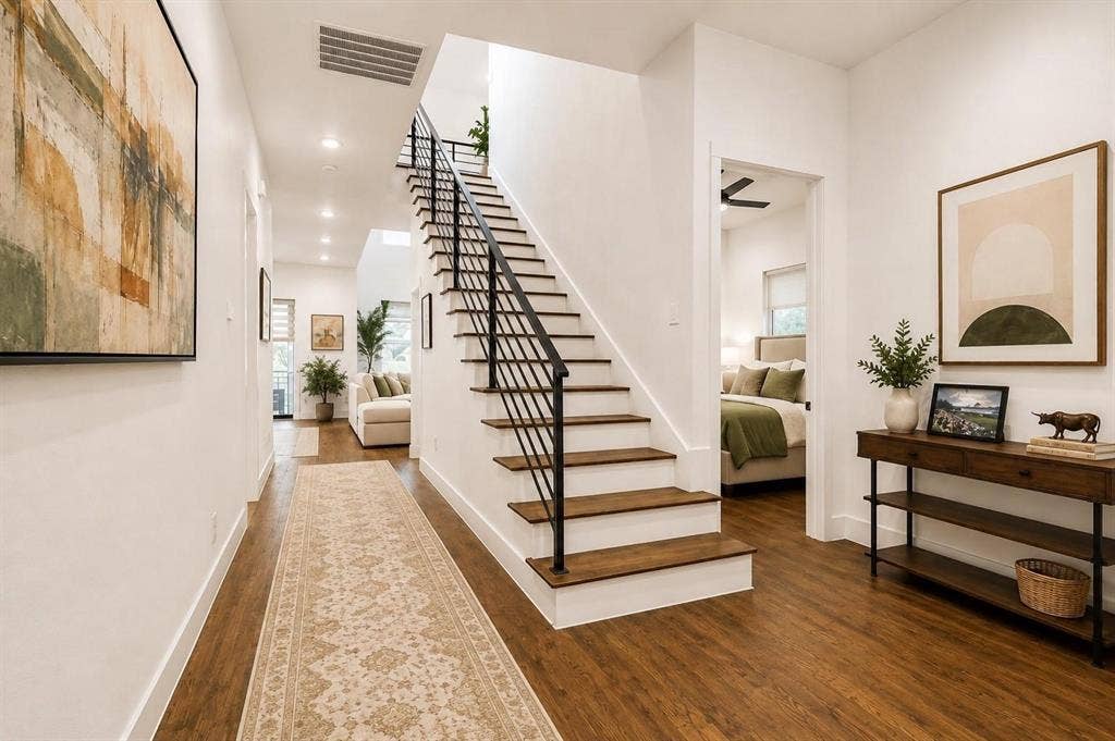 713 Wayne Street, Dallas, TX 75223 Wood-finish flooring, recessed lighting, white walls, black metal staircase railing, and an open doorway