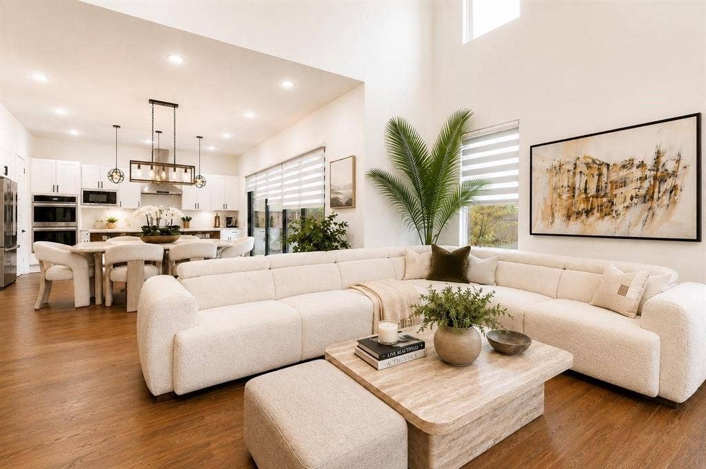 713 Wayne Street, Dallas, TX 75223 Open-concept living space featuring high ceilings, wood-finish flooring, a modern kitchen with built-in stainless steel appliances, and a dining area with pendant lighting