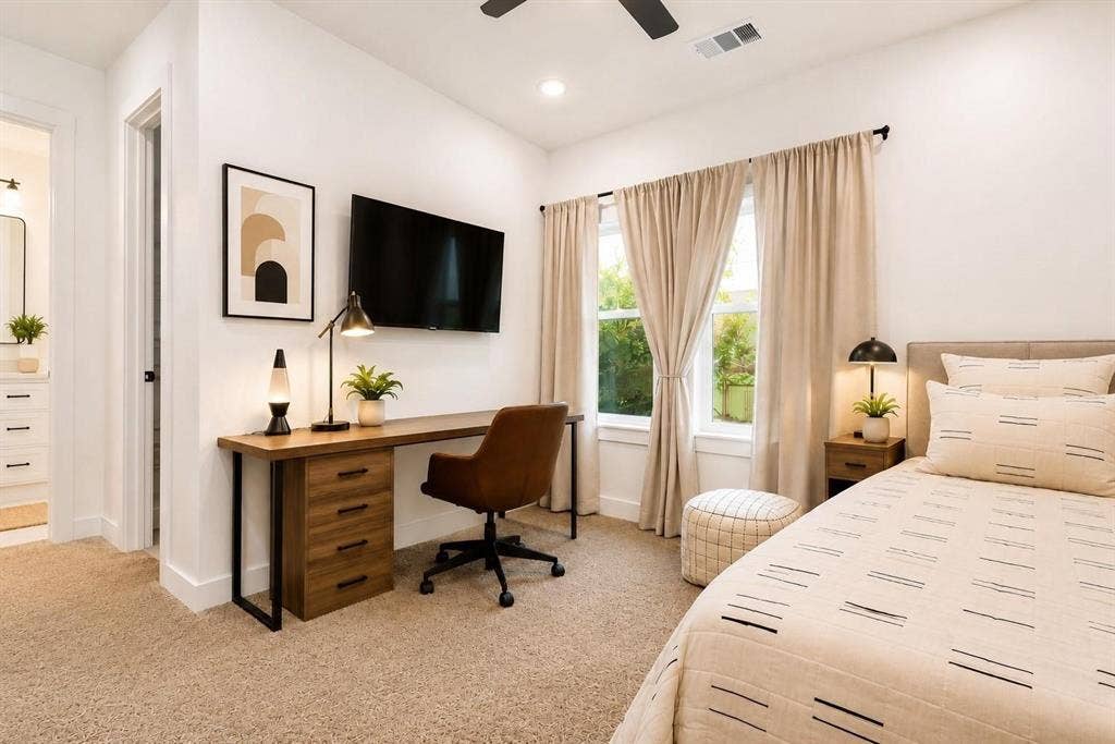 713 Wayne Street, Dallas, TX 75223 Expansive room featuring light-colored carpeting, multiple windows, a ceiling fan, and a built-in wood-finish desk