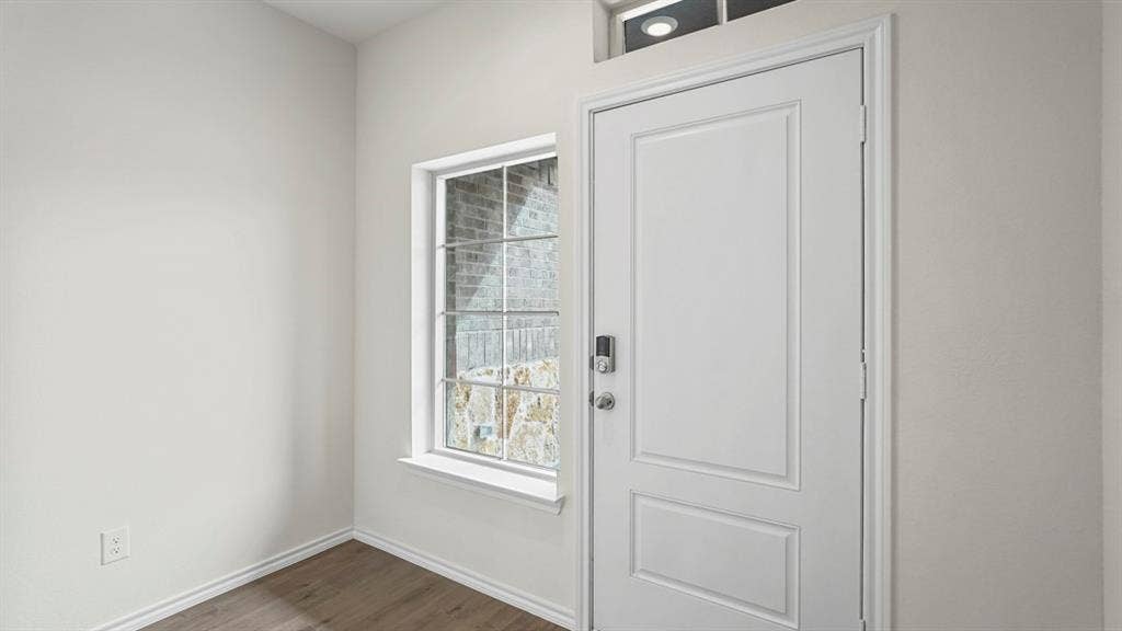 5606 Gannet Place, Crandall, TX 75114 Entryway featuring a paneled door with smart lock hardware, a transom window, and wood-finish flooring