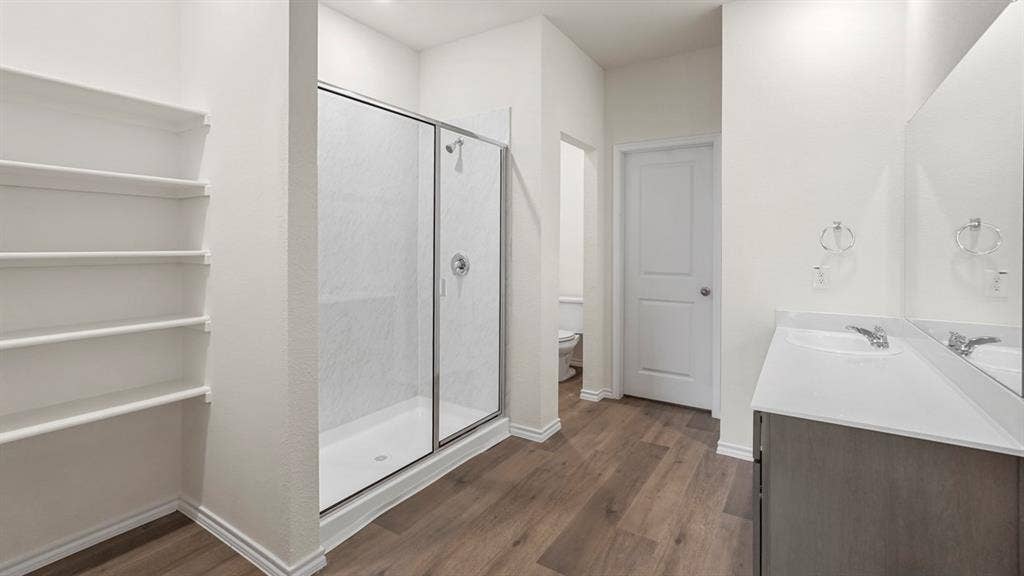 5606 Gannet Place, Crandall, TX 75114 Contemporary bathroom featuring wood-finish flooring and a spacious glass-enclosed shower