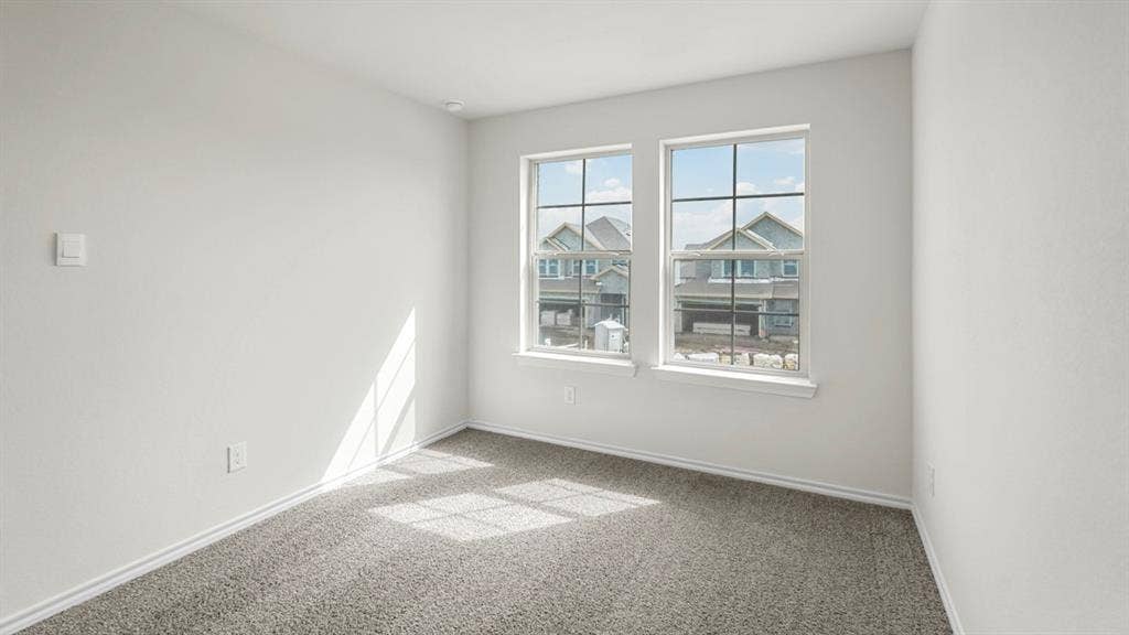 5606 Gannet Place, Crandall, TX 75114 Room featuring two windows with grid detailing, neutral-toned wall paint, gray carpeting, and white baseboards