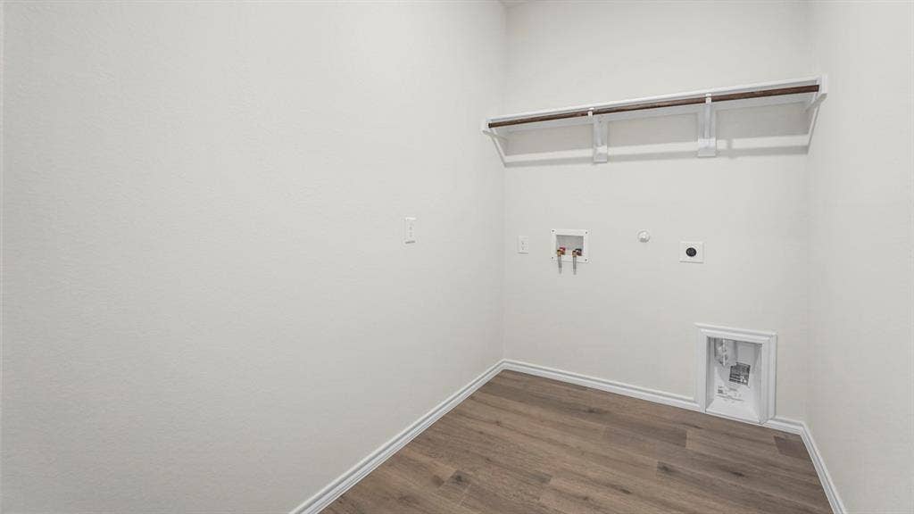 5606 Gannet Place, Crandall, TX 75114 Dedicated utility space featuring a wood-finish flooring, white baseboards, and light-toned walls