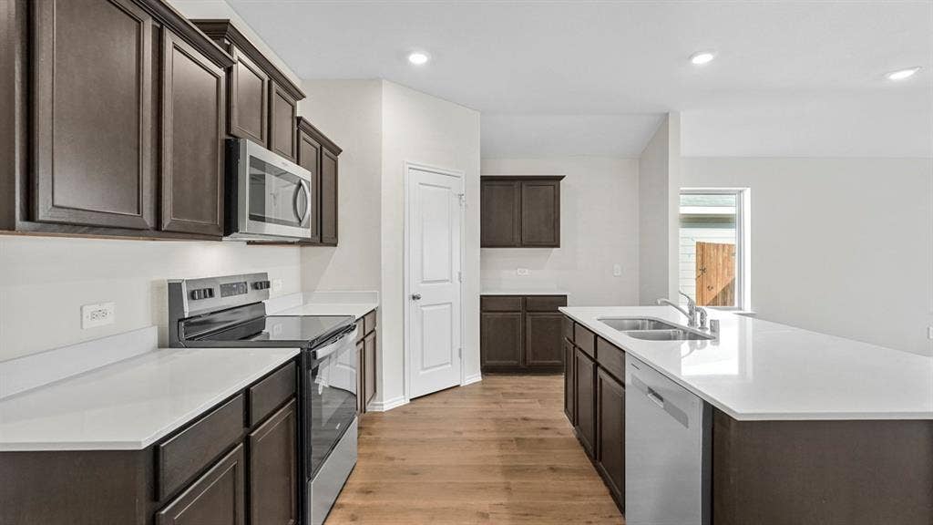 227 Whispering Pine Drive, Royse City, TX 75189 Kitchen featuring dark wood-finish cabinetry, white countertops, stainless steel appliances, and wood-finish flooring