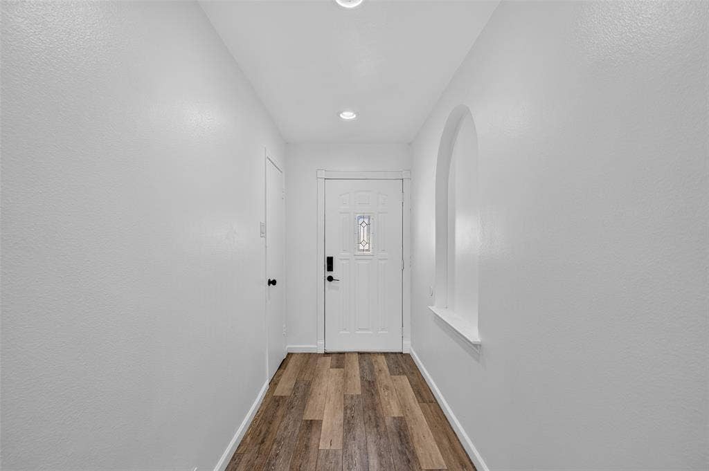 2130 Bowie Drive, Carrollton, TX 75006 Entryway featuring wood-finish flooring, recessed lighting, an arched niche, and a white paneled door with decorative glass