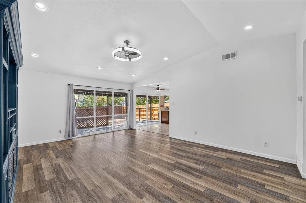 2130 Bowie Drive, Carrollton, TX 75006 Wood-finish flooring, vaulted ceiling, recessed lighting, modern ceiling fan, and sliding glass doors to outdoor patio