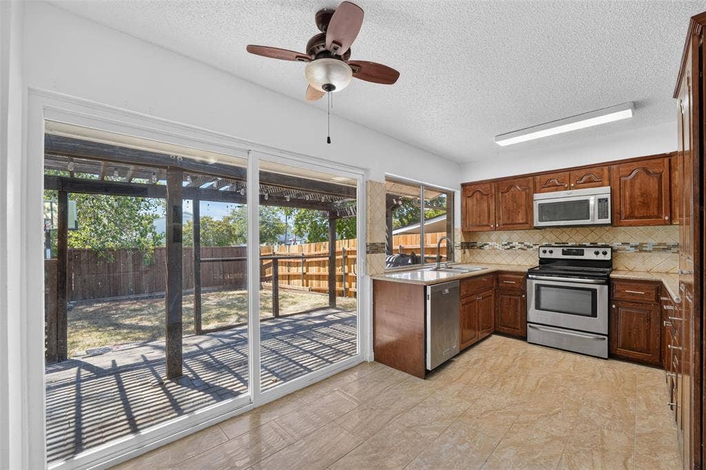 2130 Bowie Drive, Carrollton, TX 75006 Kitchen featuring wood cabinetry, stainless steel appliances, and tile flooring