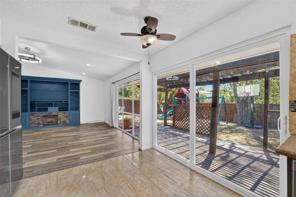 2130 Bowie Drive, Carrollton, TX 75006 Vaulted ceilings with recessed lighting, wood-finish flooring, and a built-in media center with a stone-finish fireplace